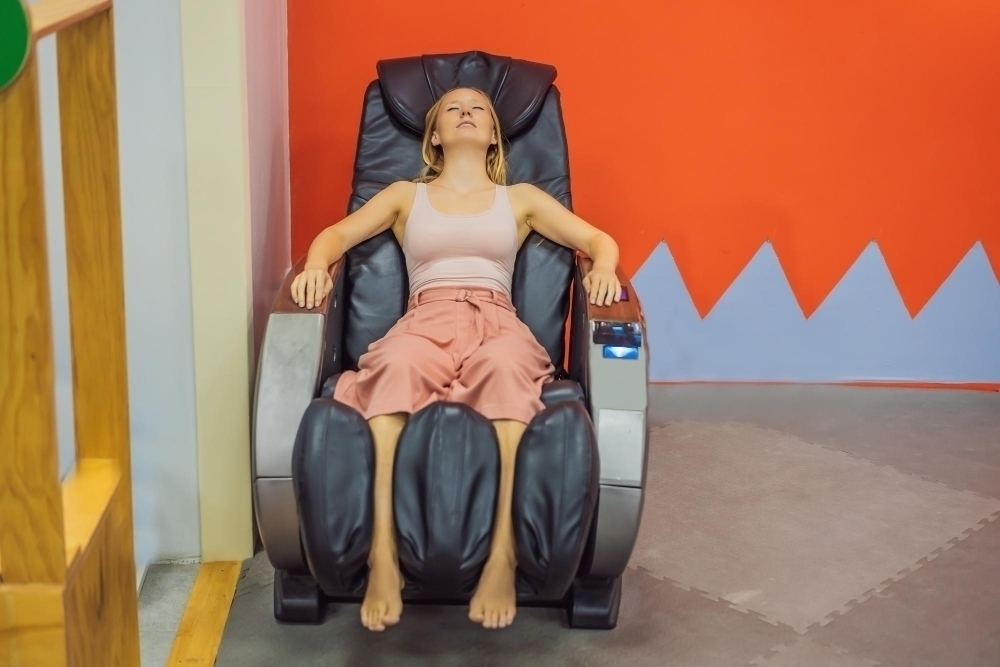 Beautiful young woman relaxing on the massage chair in airport or in the mall