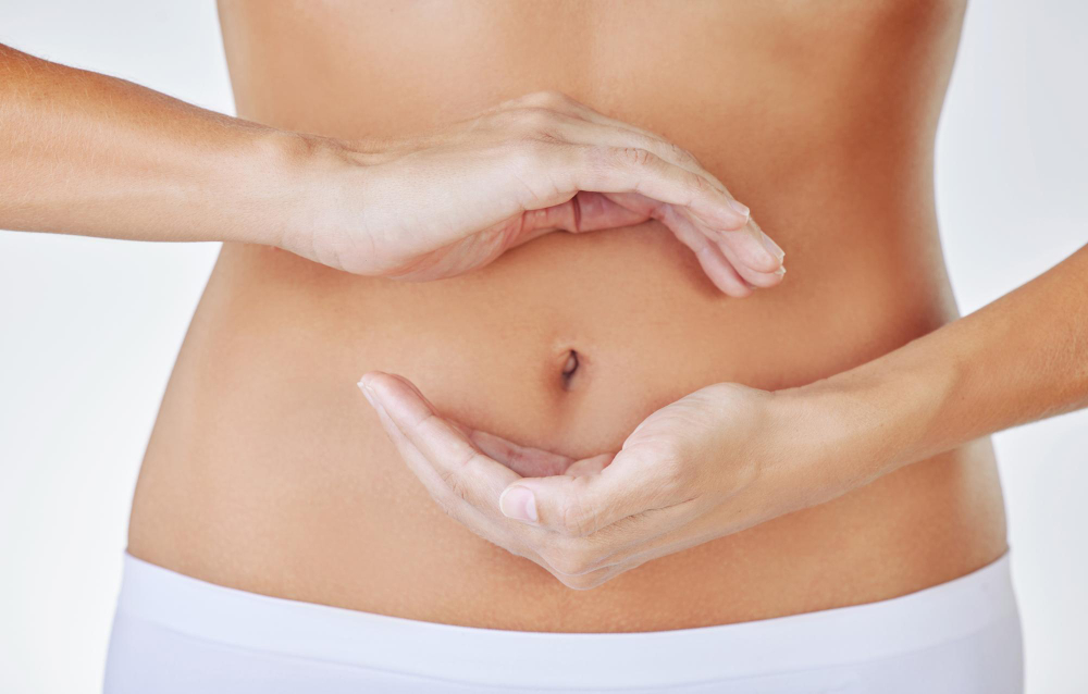 Hands frame stomach and woman in studio showing gut health wellness and weight loss Digestion female person and hand by abdomen with circle for healthy body care and fitness with white background