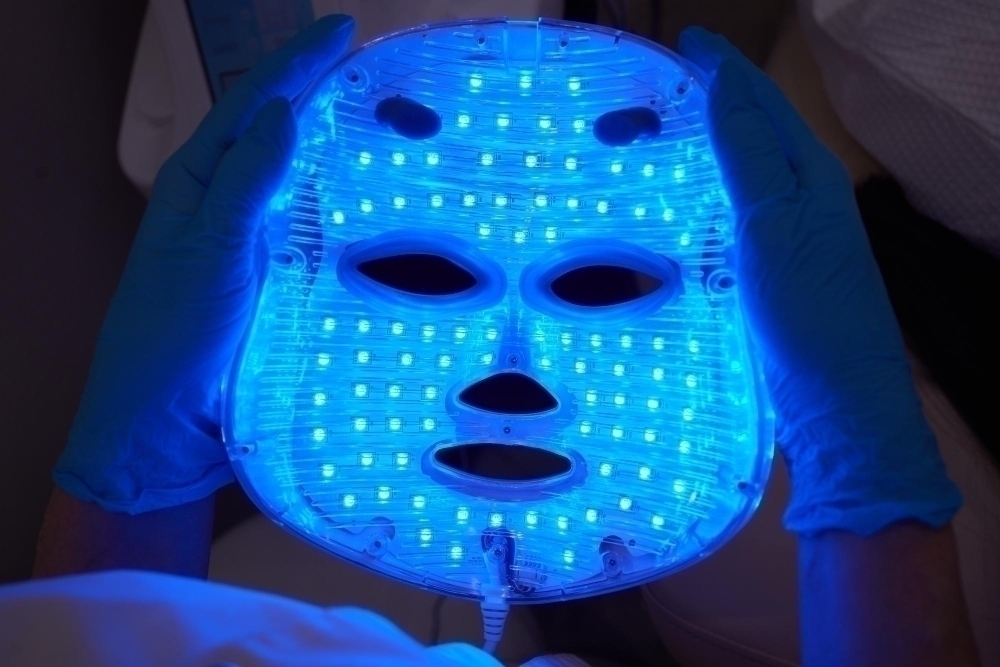 Led light antiaging mask for facial skin care in a spa slow motion a woman lies on a couch in a spec...