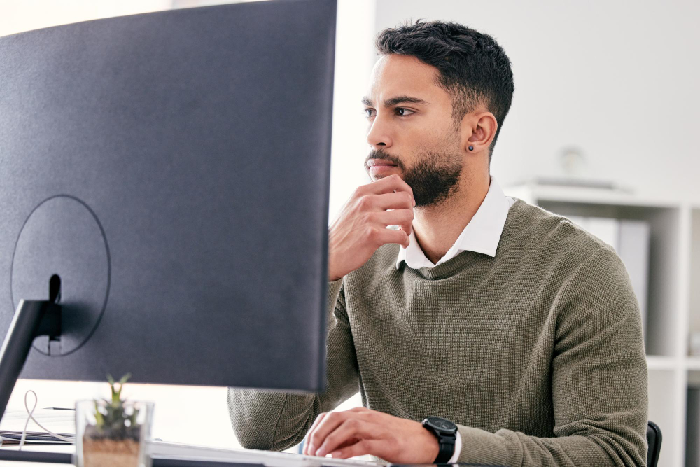 Thinking planning and business man on computer for website solution research and serious focus or job decision Reading review and choice of web designer person on desktop pc for problem solving