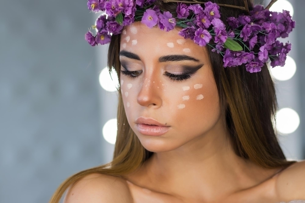 Woman in flower wreath standing with mirrors behind